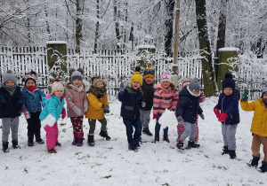 Zdjęcie przedstawia grupę dzieci w ogródku przedszkolnym.