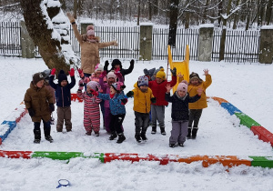 Zdjęcie przedstawia całą grupę wesoło podskakującą na śniegu.