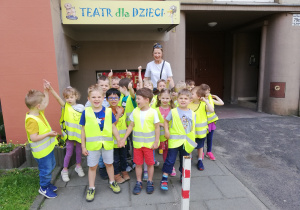 Grupa dzieci stoi przed siedziba teatru dla dzieci "Baśniowa Kawiarenka"