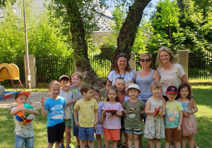zdjęciu cała grupa wraz z nauczycielkami w ogródku przedszkolnym