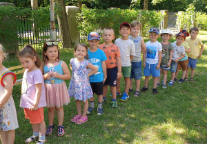 Na zdjęciu dzieci stoją ustawione "w pociąg".