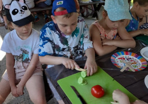 Na zdjęciu widać chłopców z grupy V podczas zajęć kulinarnych w ogrodzie przedszkolnym