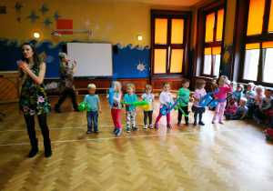 Zdjęcie przedstawia panie prowadzące koncert oraz przedszkolaków grających na zabawkowych instrumentach.