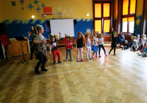 Tańczące przedszkolaki w kapeluszach jesiennych.