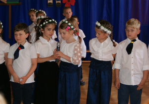 zdjęcie przedstawia dzieci z grupy VI recytujący wiersz na zakończenie roku