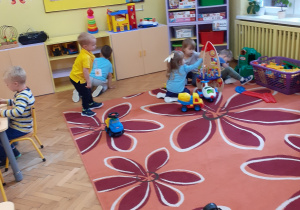 Zdjęcie przedstawia salę przedszkolną i bawiące się w niej dzieci.