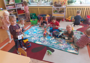 Zdjęcie przedstawia salę przedszkolną i bawiące się w niej dzieci.