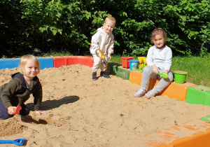 Na zdjęciu dzieci bawiące się w piaskownicy.