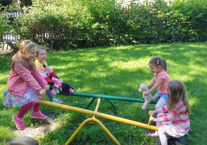 Na zdjęciu cztery dziewczynki bujające się na konikach.