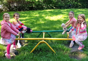 Na zdjęciu cztery dziewczynki bujające się na konikach.