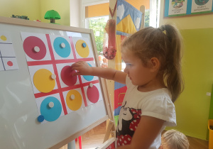 Dziewczynka układa sudoku z kropek