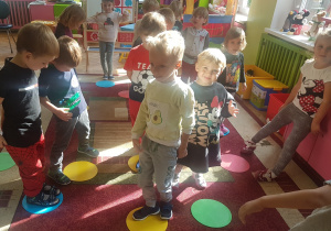 Dzieci bawią się w zabawę ruchową „Znikające kropki” przy muzyce