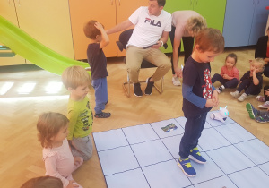 dzieci uczestniczą w zabawie z robotem Photon i specjalną matą do kodowania