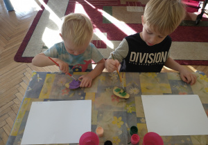 Dwóch chłopców maluje farbami ziemniaki