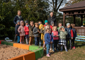 Dzieci z grupy czwartej "Żabki" wraz z nauczycielką i Panem Maciejem pozują na tle zasadzonego grupowego drzewa