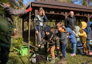 Przedszkolaki podczas przysypywania drzewa ziemiom