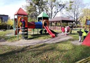 dzieci podczas jesiennych harców na przedszkolnym placu zabaw