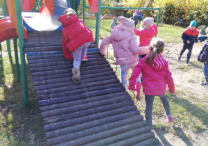 dzieci podczas jesiennych harców na przedszkolnym placu zabaw