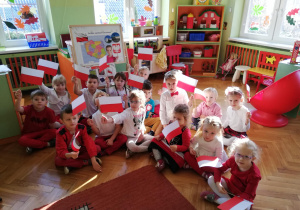 grupa dzieci pokazuje własnoręcznie wykonane flagi Polski
