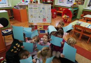 Dzieci oglądają poszczególne kartki książeczki Konwencja o Prawach Dziecka