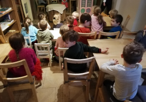 dzieci oglądają spektakl " Jasełka w "Baśniowej Kawiarence" - w tle aktorzy z lalkami