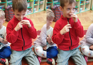 Na zdjęciu chłopiec wąchający płyn bursztynowy.