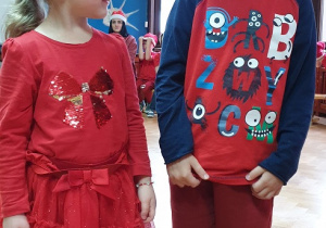 Na zdjęciu dwoje dzieci w mikołajkowych ubraniach