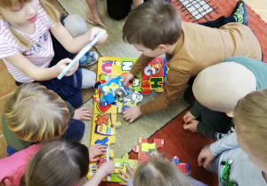 Dzieci na dywanie układają puzzle piankowe