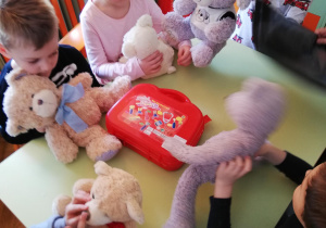 dzieci przy stolikach wraz ze studentką podczas zabaw oswajających dzieci z pracą lekarza i pielęgniarki
