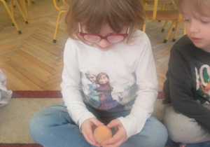 Dziewczynka w białej bluzce ogląda wynik eksperymentu
