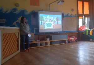 Na zdjęciu nauczycielka pokazuje dzieciom film edukacyjny o tym jak należy dbać o naszą planetę