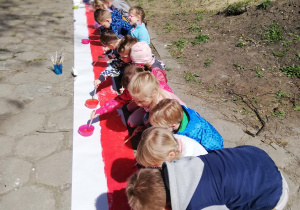 widok z ogródka na namalowaną przez dzieci flagę