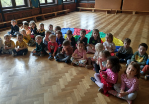 Dzieci na sali gimnastycznej oglądają prezentację