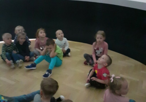 Na zdjęciu dzieci oglądają bajkę wyświetlaną na ścianach balonu sferycznego.