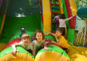 Na zdjęciu dzieci bawiące się na dmuchanym zamku.