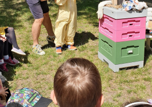Na zdjęciu chłopiec zakłada strój pszczelarza.