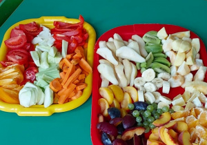 Zdjęcie przedstawia dwie tace pełne pokrojonych, przygotowanych do zjedzenia owoców i warzyw.