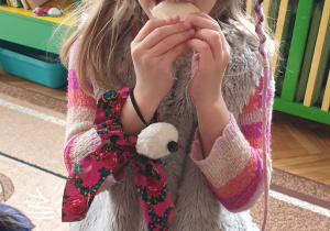 Zdjęcie przedstawia dziewczynkę jedzącą kalarepkę.