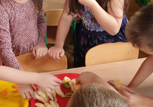 Zdjęcie przedstawia dwie dziewczynki jedzące owoce.