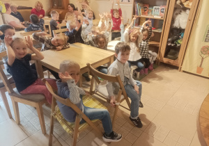 Na zdjęciu grupa dzieci siedzi przy stolikach w Baśniowej Kawiarence.