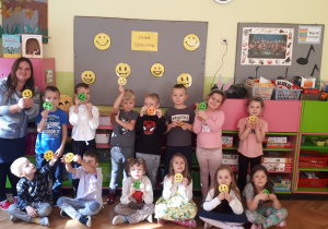 na zdjęciu dzieci z grupy Misie wraz z nauczycielką z emblematami uśmiechniętych buzi