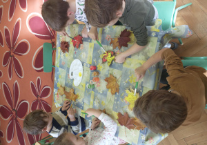 Dzieci z gr 3 malują liście farbami
