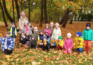 Na zdjęciu cała grupa z nauczycielką na tle jesiennych drzew.