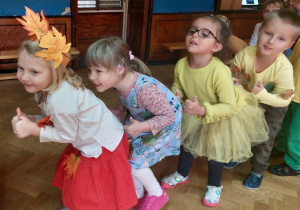 Dzieci w jesiennych kostiumach tańczą przy piosence „Krasnoludek”