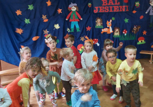 Dzieci w jesiennych kostiumach tańczą przy piosence o tematyce jesiennej