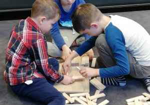 na zdjęciu dzieci budujące wieże i inne konstrukcje z drewnianych klocków Linden. ch klocków