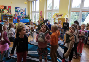 dzieci w klasie na dywanie tańczą ze swoimi pluszakowymi zwierzakami