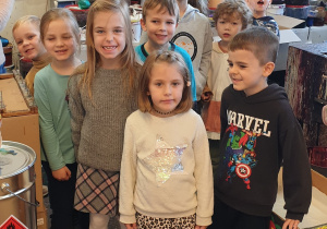 Na zdjęciu grupa dzieci w pomieszczeniu w którym farbuje się bombki.