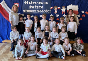 Grupa 5 z nauczycielkami pozuje na tle napisu Dzień Niepodległości i flagi Polski.