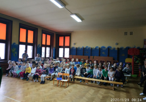 przedszkolaki siedzące na ławkach podczas oglądania przedstawienia